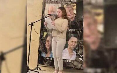Former hostage Emily Hand speaks on May 21, 2025, at a Kibbutz Be'eri rally held for the hostages in the kibbutz's temporary quarters in Kibbutz Hazerim. (Courtesy Kibbutz Be'eri)